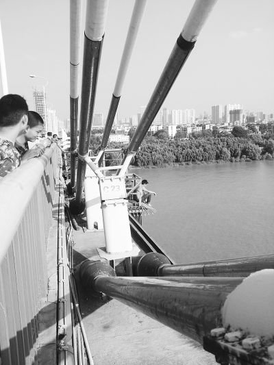 男子赤膊爬到长江二桥外的维修台上欲寻短见